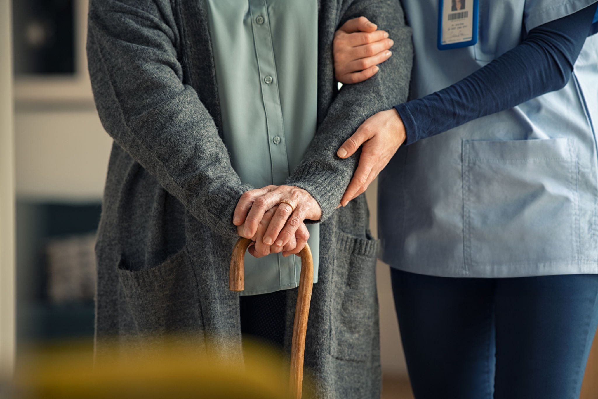 Caregiver providing walking support; shared stock placeholder